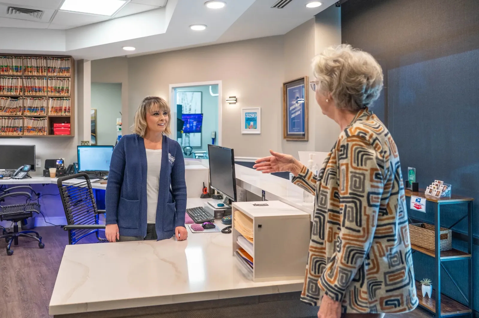 A patient being welcomed at the Highpoint Dental front desk